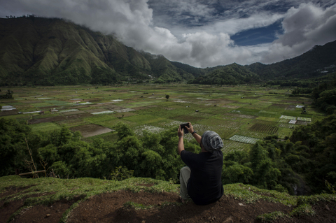 Wisatawan memotret dengan gawai di Bukit Selong, Sembalun Lawang, Sembalun, Lombok. Foto: ANTARA FOTO/Aprillio Akbar