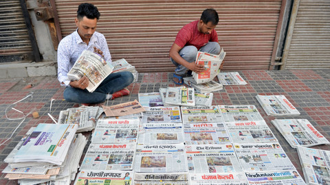 Sejumlah pedagang korang menyiapkan koran yang menampilkan berita halaman depan tentang pemboman hari Minggu Paskah di Sri Lanka. Foto: AFP/NARINDER NANU