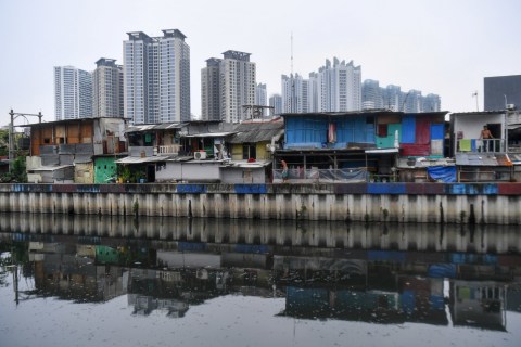 Warga beraktivitas di rumahnya berlatar belakang hunian bertingkat di kawasan Sunter, Jakarta Utara, Sabtu (9/5/2020). Foto: ANTARA FOTO/Sigid Kurniawan