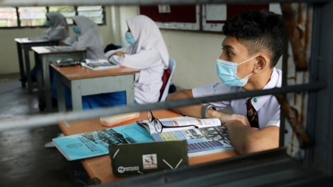 Pelajar mengenakan masker saat kegiatan belajar di ruang kelas pada salah satu sekolah menengah di Shah Alam, Malaysia, Rabu (24/6). Foto: Lim Huey Teng/Reuters