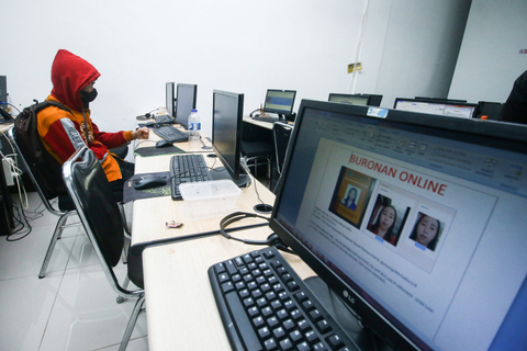 Pegawai PT Ant Information Consulting (AIC) duduk di depan komputer saat penggerebekan kantor pinjaman online ilegal di Kelapa Gading, Jakarta, Senin (18/10).  Foto: Rivan Awal Lingga/ANTARA FOTO
