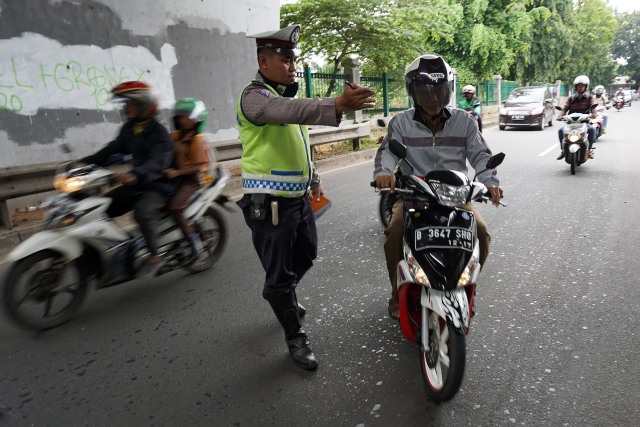 Polisi tengah melakukan razia rutin untuk menertibkan pengendara sepeda motor di Jakarta. Pengendara ini tidak menyalakan lampu depan, polisi menindak. (Foto: Aditia Noviansyah)