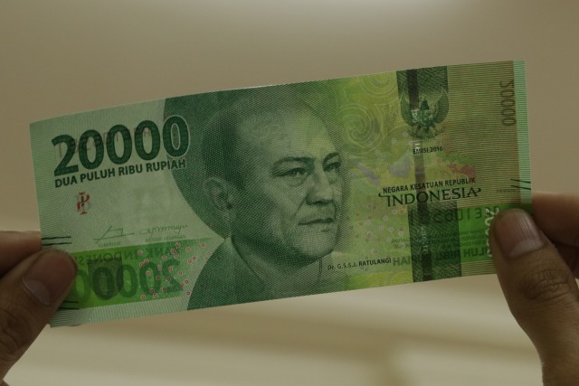 Uang baru pecahan RP 20 ribu dilihat di bawah sinar lampu (Foto: Fanny Kusumawardhani/kumparan)