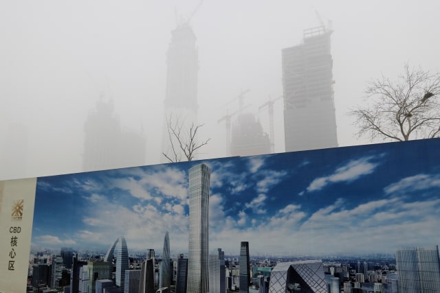 Polusi udara di Beijing, China tampak begitu kontras dengan potret sebuah baliho di jalanan.  Foto: APexchange