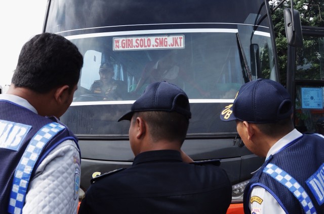 Tiga petugas Dishub sedang memerika sebuah bus. Foto: Fanny Kusumawardhani/kumparan