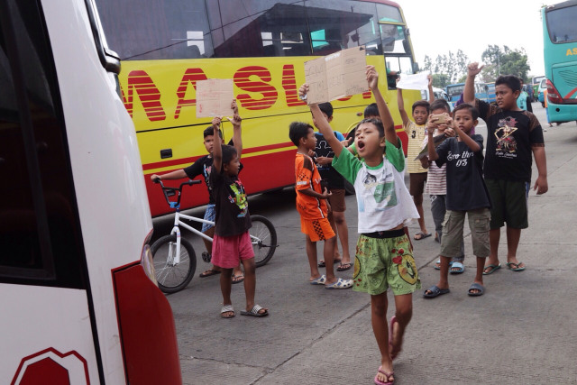 Anak-anak di kawasan Terminal Kalideres  mencari bus yang memiliki suara klakson khas yg berbunyi "telolet" (Foto: Fanny Kusumawardhani)