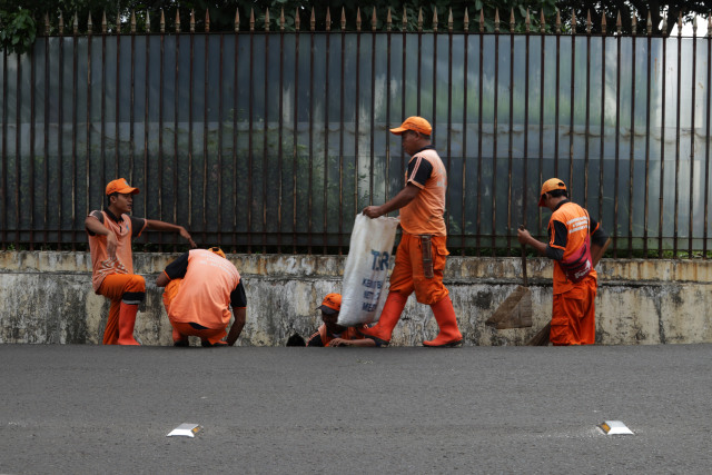 Pasukan Oranye "bertempur" membersihkan jalanan ibu kota. (Foto: Fanny Kusumawardhani/kumparan)