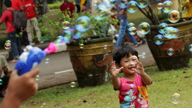 Seorang anak gembira bermain gelembung sabun. (Foto: Fanny Kusumawardhani/kumparan)