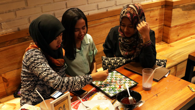 Makan sambil bermain di warung Upnormal. (Foto: Fanny Kusumawardhani/kumparan)