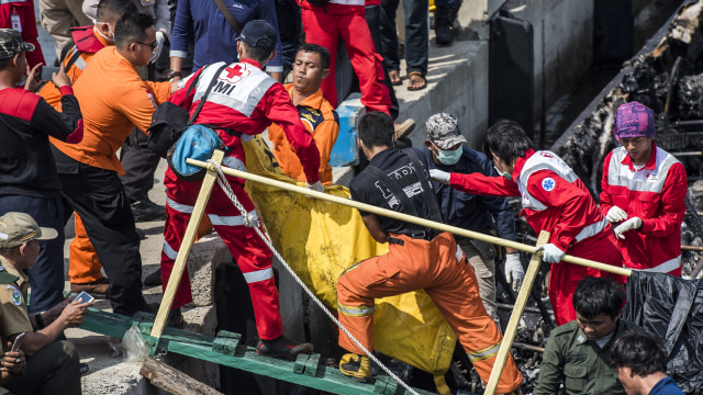 Petugas mengangkat kantung mayat korban (Foto: M Agung Radjasa/Antara)