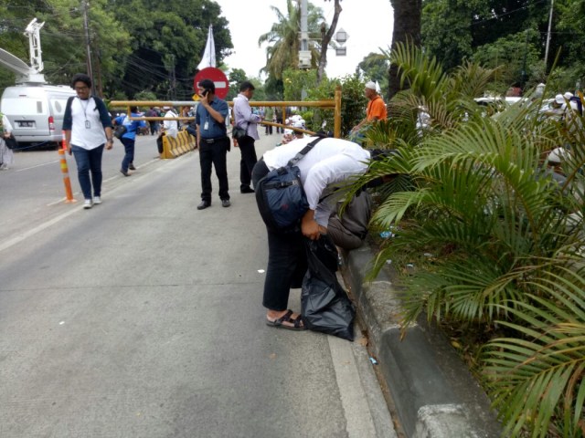 Massa anti Ahok mengumpulkan sampah (Foto: Viry Alifiyadi/kumparan)