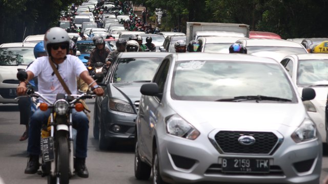 Mobil dan motor berbagi di jalan raya. (Foto: ANTARA/Rivan Awal Lingga)