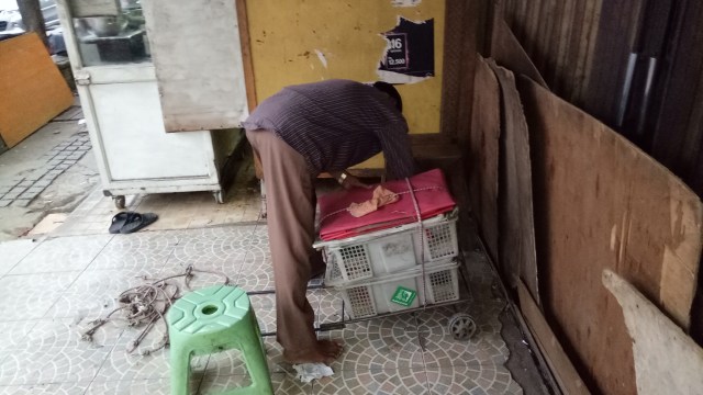 Pak Abdul saat hendak membuka lapak (Foto: Ochi Amanaturrosyidah/kumparan)