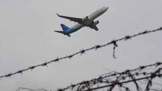 Sebuah pesawat melintas di dekat bandara. (Foto: Aditia Noviansyah/kumparan)