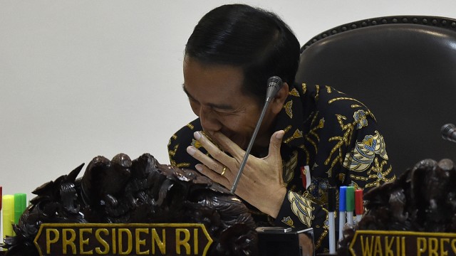 Jokowi tertawa tertahan sebelum ratas. Foto: Puspa Perwitasari/Antara