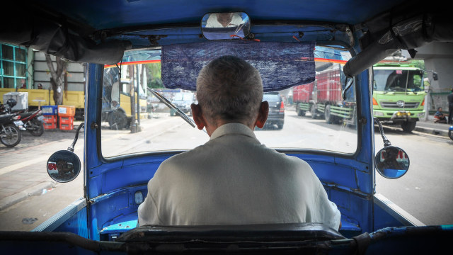 Engkong Sariah, fokus mengemudikan bajajnya. (Foto: Kevin Kurnianto/kumparan)