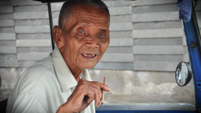 Senyum Engkong Sariah pengemudi bajaj. (Foto: Kevin Kurnianto/kumparan)