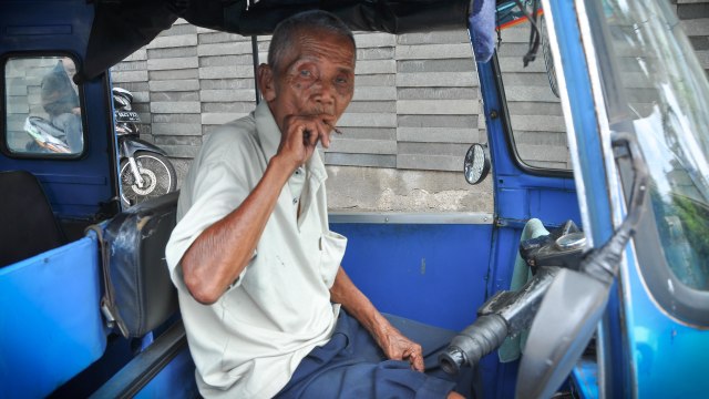 Engkong Sariah menghisap sebatang rokok. (Foto: Kevin Kurnianto/kumparan)