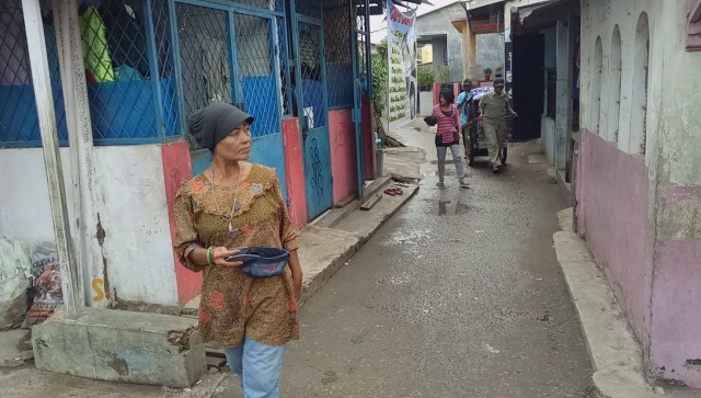 Mulyani mengunakan topi sebagai wadah uang. (Foto: Mustaqim Amna/kumparan)