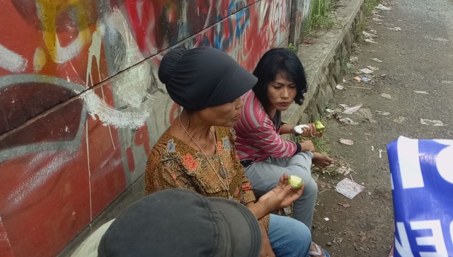 Mulyani rehat sejenak sambil menikmati jambu biji. (Foto: Mustaqim Amna/kumparan)