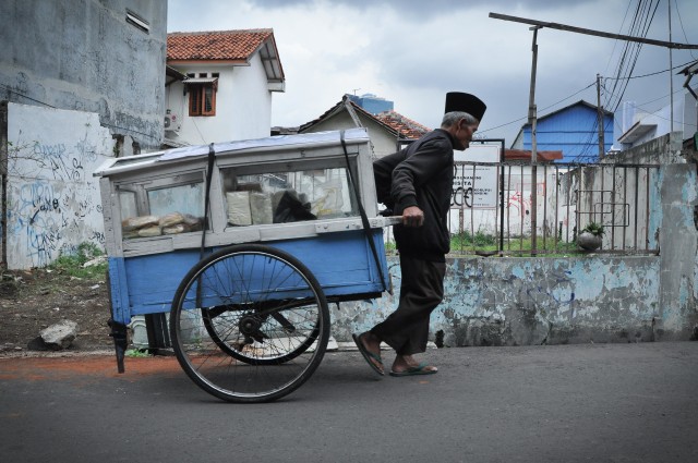 Kakek Khaerudin menarik gerobak rotinya. (Foto: Kevin Kurnianto/kumparan)