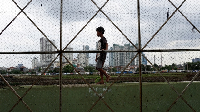 Seorang anak melintasi di tembok pembatas pagar  (Foto: Aditia Noviansyah/kumparan)