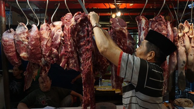 Penjual sedang mengantung daging sapi. (Foto: Aditia Noviansyah/kumparan)