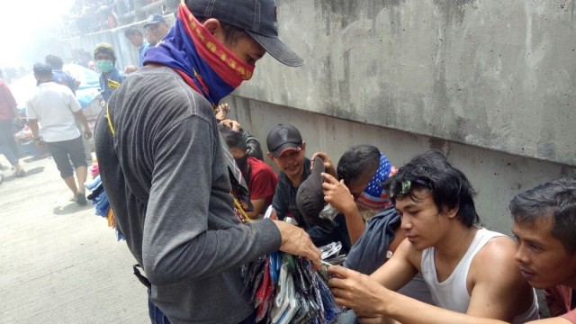 Ucup, berjualan buff di kebakaran Pasar Senen (Foto: Nikolaus Harbowo/kumparan)