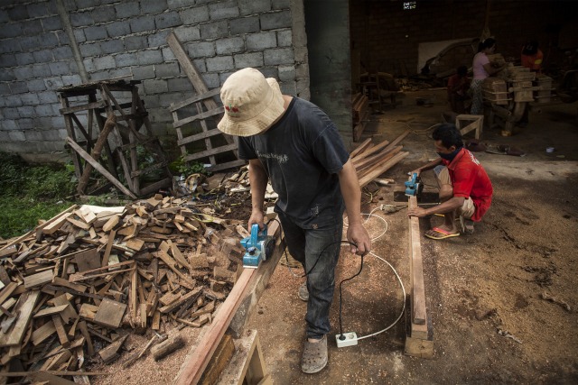 Pekerja sibuk mengolah kayu limbah (Foto: Maulana Surya/Antara)