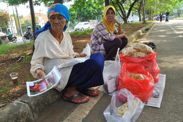 Nenek Saidah sedang berjualan di pinggir jalan (Foto: Kevin Kurnianto/kumparan)