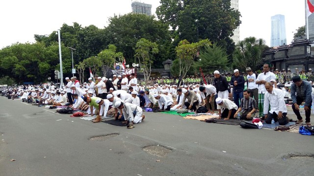 Salat zuhur dilakukan di depan jalan raya. (Foto: Aria Pradana/kumparan)