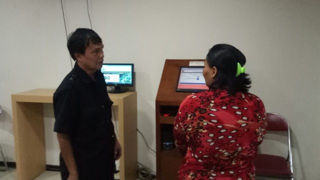 Petugas membantu ibu di kantor kelurahan. (Foto:  Muhammad Iqbal/kumparan)