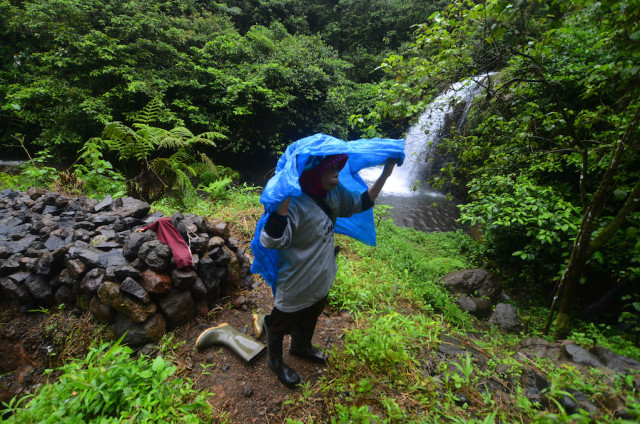 Berteduh di kala hujan (Foto: Adeng Bustomi/Antara Foto)