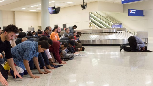 Imigran muslim yang ditolak AS, salat di bandara. (Foto: Laura Buckman/REUTERS)