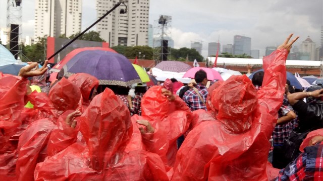 Tetap mendukung walau hujan turun. (Foto: Johannes H/kumparan)