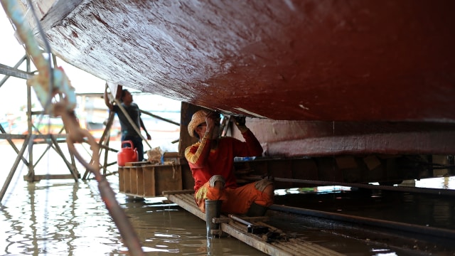 Nelayan sedang memeriksa kondisi perahunya. (Foto: Aditia Noviansyah/kumparan)