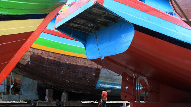 Seorang nelayan di antara perahu-perahu besar. (Foto: Aditia Noviansyah/kumparan)