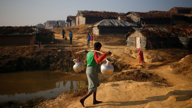 Pengungsi Rohingya membawa air. (Foto: Reuters/Mohammad Ponir Hossain)