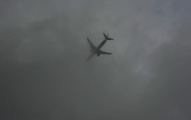 Sebuah pesawat menerobos awan tebal. (Foto: Antara/Yusran Uccang)