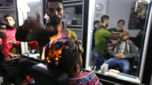 Menata rambut saat api masih menyala. (Foto: Reuters)