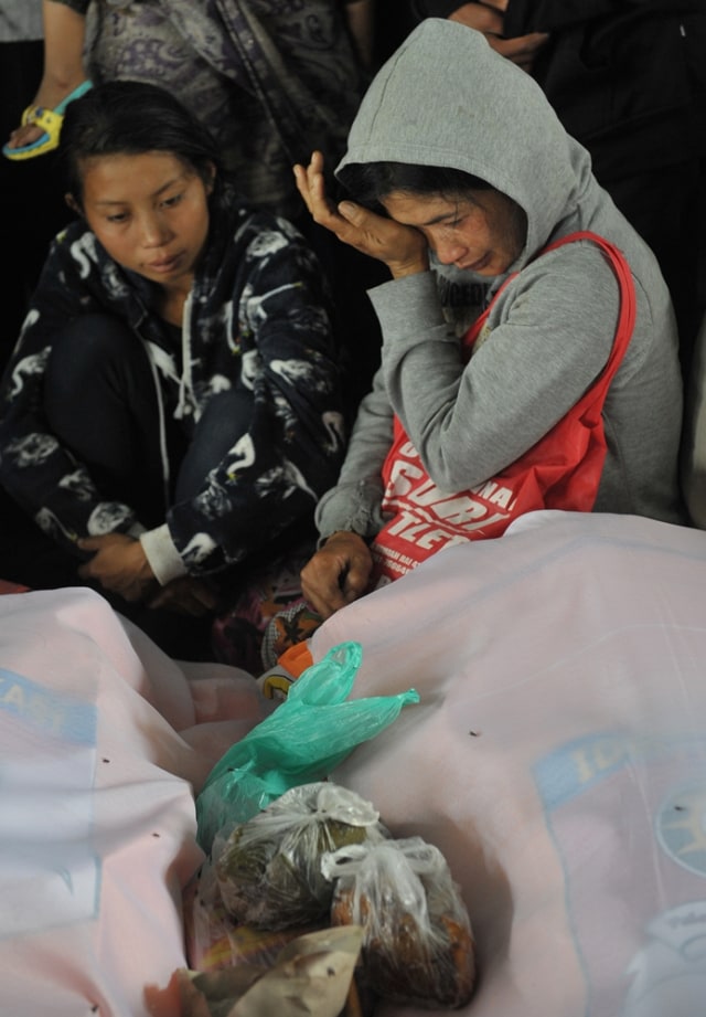 Warga menangis di samping jenazah korban longsor. (Foto: Antara/Nyoman Budhiana)