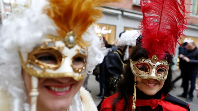 Peserta Karnaval berpose menggunakan topeng. (Foto: Reuters/Tony Gentile)