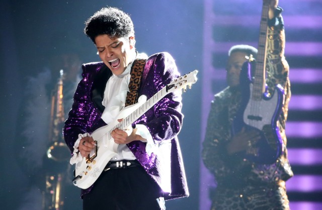 Bruno Mars tampil dengan gitar elektriknya. (Foto: Lucy Nicholson/Reuters)