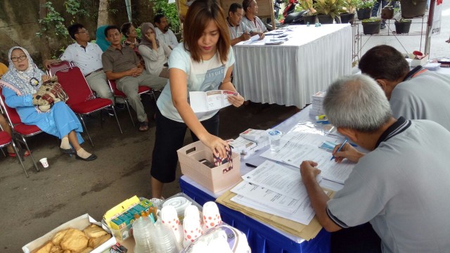 Seorang perempuan menitipkan barangnya di KPSS. (Foto: Aria Pradana/kumparan)