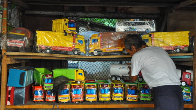 Menata mainan kayu dagangannya. (Foto: Kevin Kurnianto/kumparan)