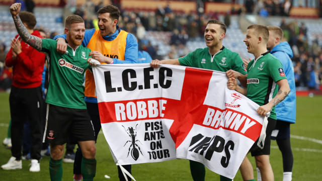 Pemain Lincoln City membawa bendera dari fans. (Foto: Jason Cairnduff/Reuters)