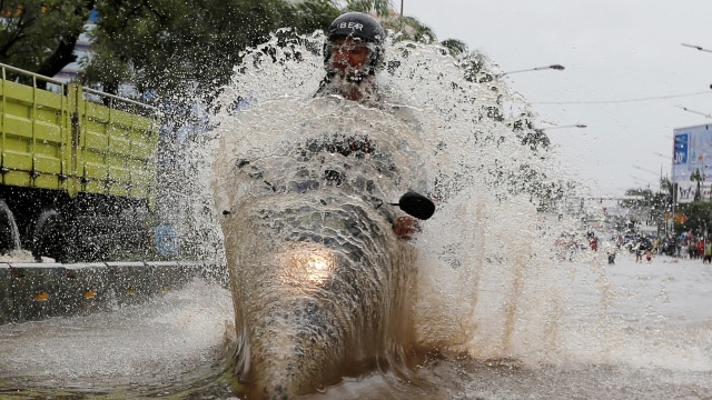 Pengendara motor menerobos banjir. (Foto: Reuters/Beawiharta)