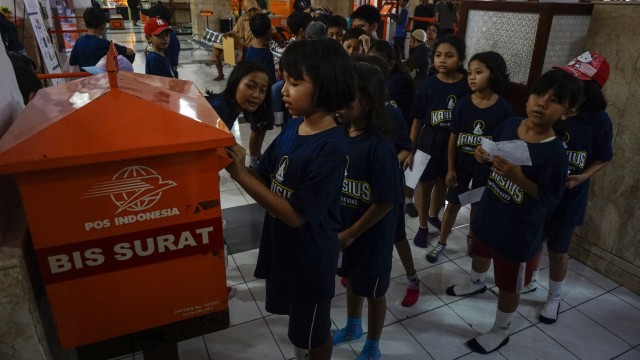 Anak SD belajar cara mengirim surat via pos. (Foto: Hendra Nurdiansyah/Antara)