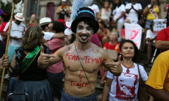 Peserta pesta jalanan menolak Presiden Temer (Foto: REUTERS/Pilar Olivares)