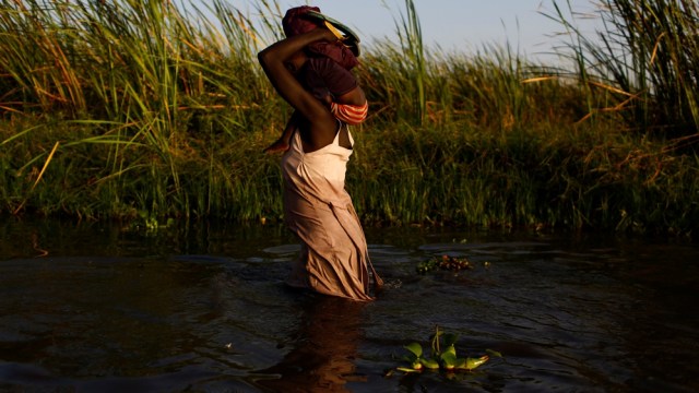 Seorang ibu menuju posko bantuan makanan dari PBB. (Foto: Reuters/Siegfried Modola)